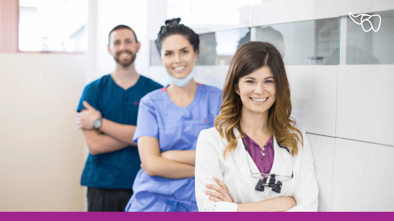Smiling dentist with two clinical team members
