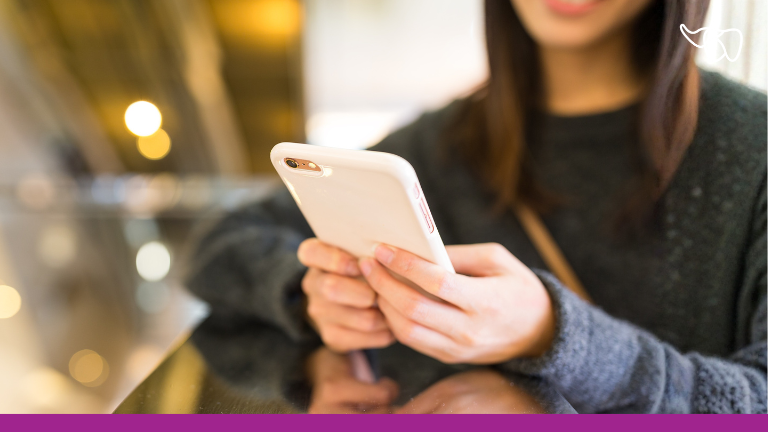 A dental patient receives a text message appointment reminder on her mobile device